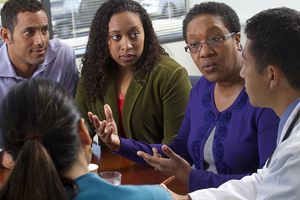 A woman and family talking to healthcare team.
